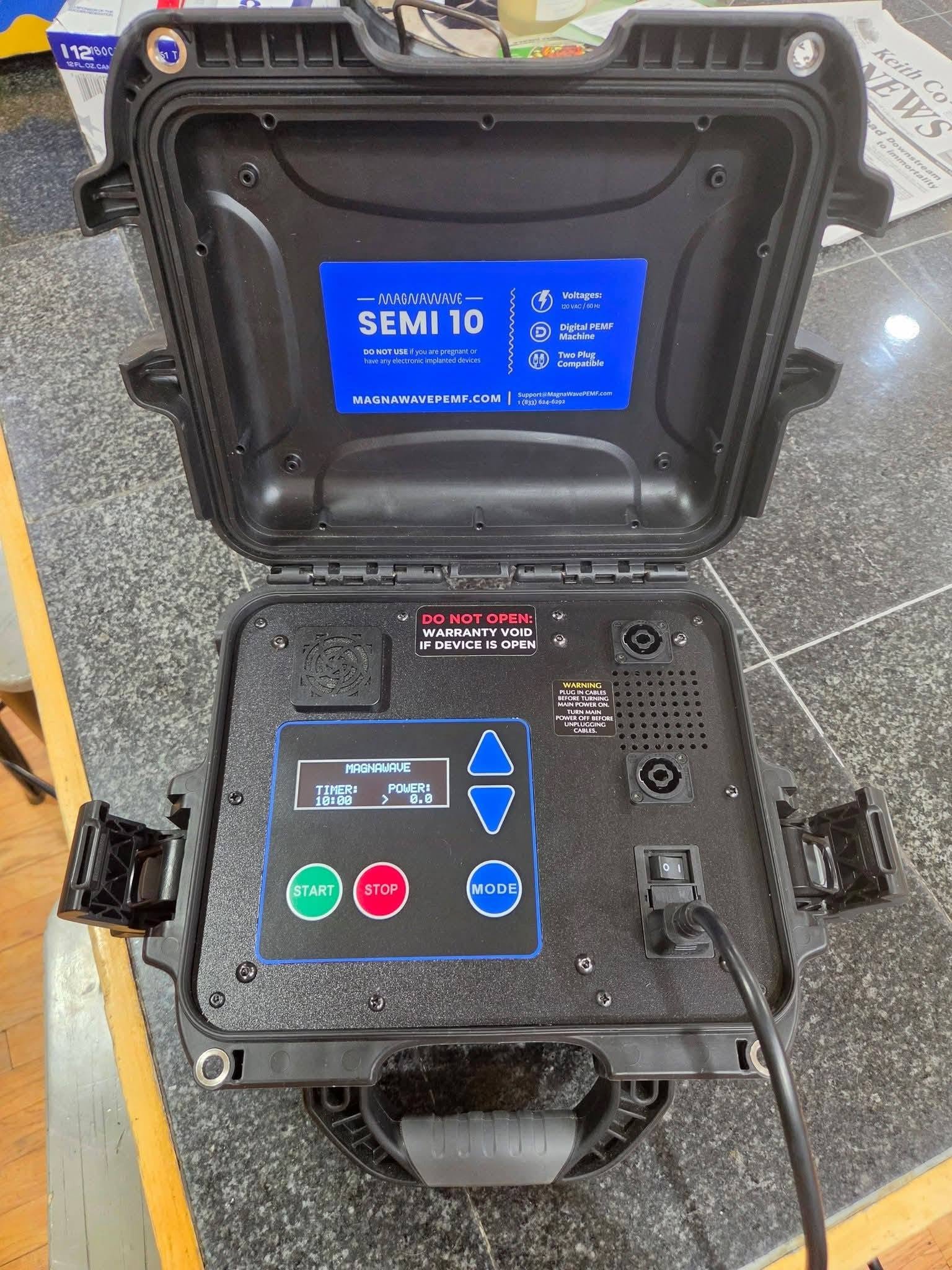 An open MagnaWave Semi-Pro 10 control unit in its hard case, showing the display and start, stop and mode buttons